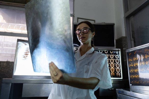 Жінка-лікар дивиться рентгенівську плівку в медичній лабораторії в лікарні. Анатомія діагностична наука людини
. - Фото, зображення