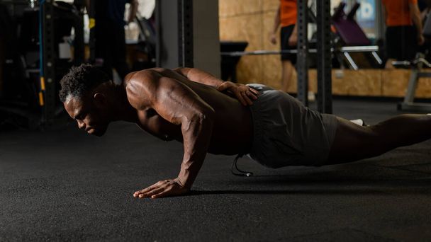 Αφροαμερικάνος που κάνει κάμψεις στο ένα χέρι στο γυμναστήριο - Φωτογραφία, εικόνα