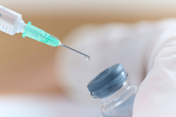 Doctor's hand sucking injection medicine from vial bottle - Foto, Imagem