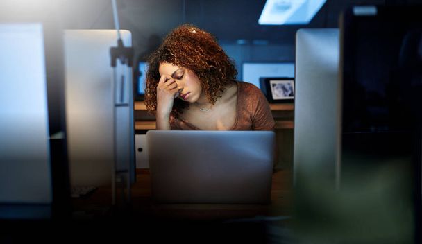 Поздние ночи берут свое. молодая женщина работает допоздна в пустом офисе - Фото, изображение
