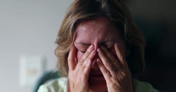 Worried older woman portrait feeling anxiety. Senior woman in 60s covering face - Metraje, vídeo