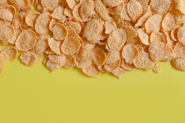 Cornflakes on yellow background, cornflakes breakfast food and snack for healthy food concept, morning breakfast fresh whole grain cereal - Fotoğraf, Görsel