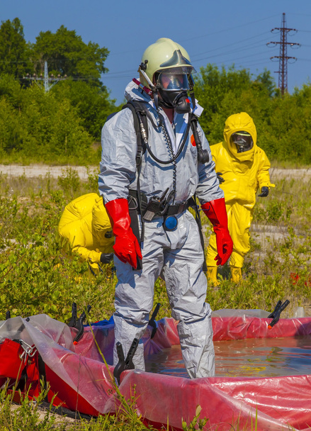 Los miembros del equipo de materiales peligrosos han estado usando trajes de protección para protegerlos de materiales peligrosos
 - Foto, Imagen