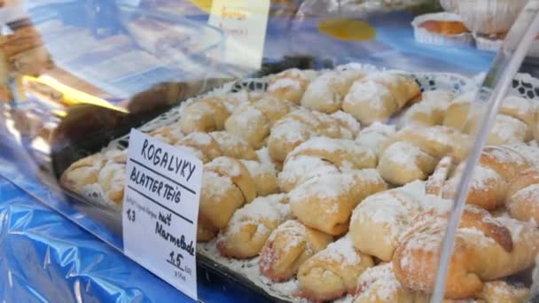 The inscription in German, the name of the croissants. Homemade baked croissants with filling, on the market stall at the fair. - Video