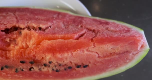 Huge piece of red watermelon lies on a plate. Panorama above the plate, top view, close-up. High quality 4k footage - Felvétel, videó