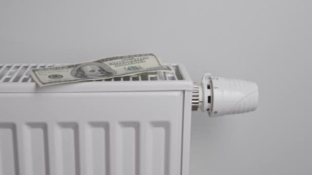 Counting dollar bills near heating radiator, Energy crisis concept, Rising costs in private households for gas bill due to inflation and war - Filmmaterial, Video