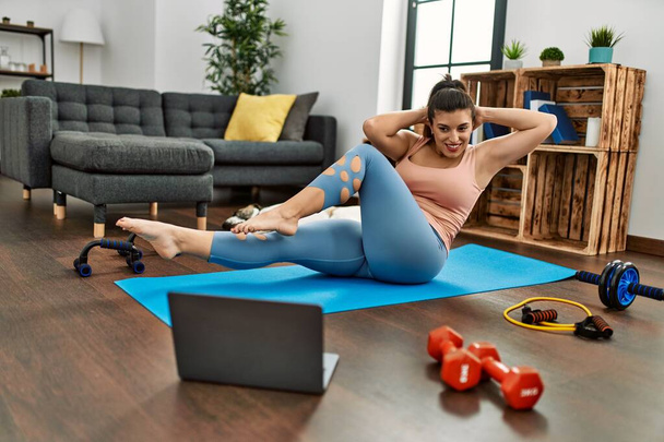 Young woman smiling confident having online abs exercise class at home - Photo, Image