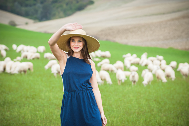 Beautiful woman in a field between the Tuscan sheep - Fotografie, Obrázek