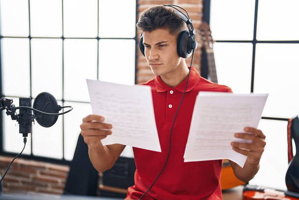 Young hispanic man musician singing song at music studio - Fotó, kép