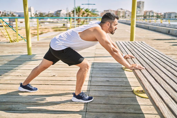 Spanisch Mann Stretching nach dem Training im Freien an einem sonnigen Tag - Foto, Bild
