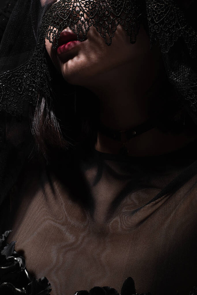 cropped view of young woman posing under black veil  - Zdjęcie, obraz