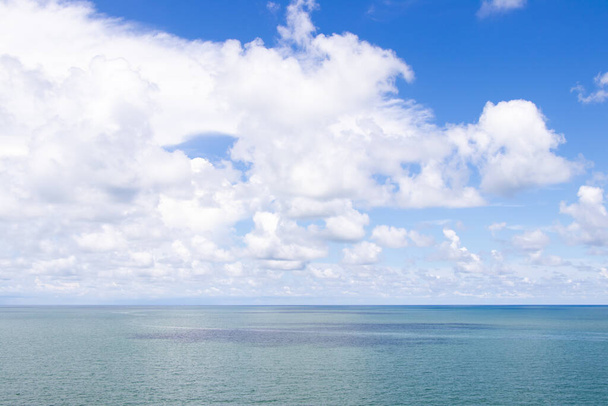 Güzel sakin turkuaz renkli deniz ve beyaz renkli bulutlu mavi gökyüzü. - Fotoğraf, Görsel