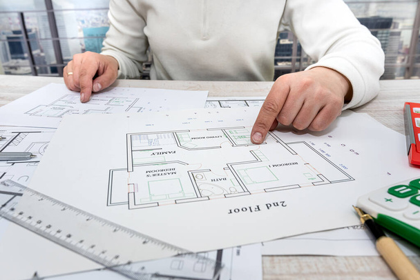 a professional architect makes a custom sketch of an apartment building in a large complex. Male hands draw sketches of drawings at the table - Valokuva, kuva