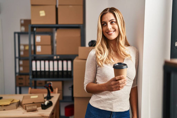 Junge blonde Frau E-Commerce-Unternehmer trinkt Kaffee im Büro - Foto, Bild