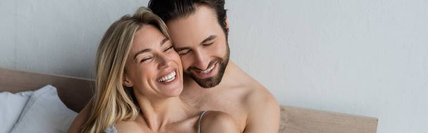 happy lovers smiling with closed eyes in bedroom, banner - Foto, imagen