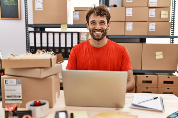 Joven hombre hispano sonriendo confiado trabajando en el almacén - Foto, Imagen