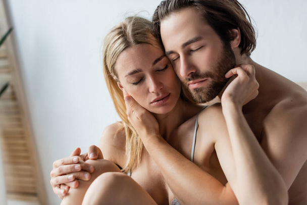сексуальные любовники с закрытыми глазами, обнимающиеся в спальне дома - Фото, изображение