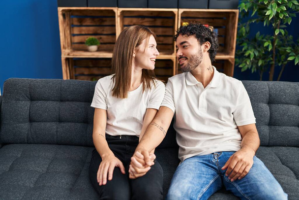 Man and woman smiling confident with hands together at home - Foto, imagen