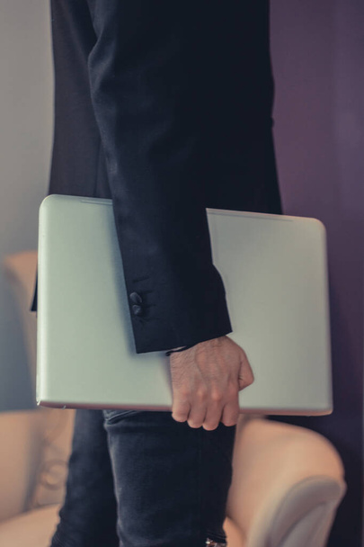 Unrecognizable businessman holding laptop.  - Zdjęcie, obraz