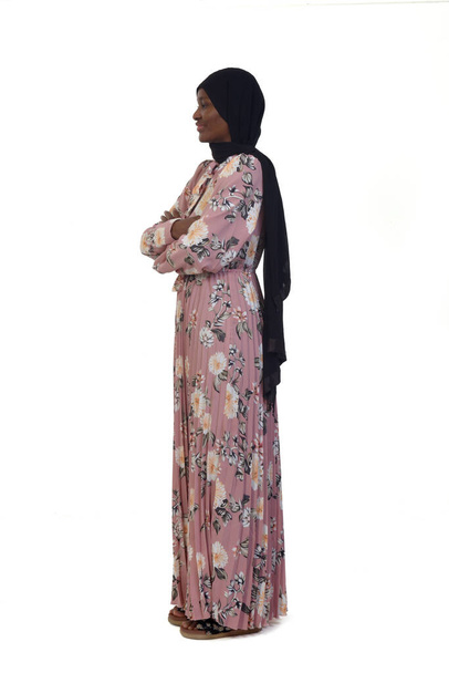 side view of a woman standing arms crossed, dress and burka over white background - Foto, Imagem