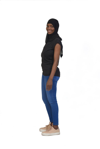 side view of a woman with casual clothing and burka looking at camera on white background - Foto, Imagem