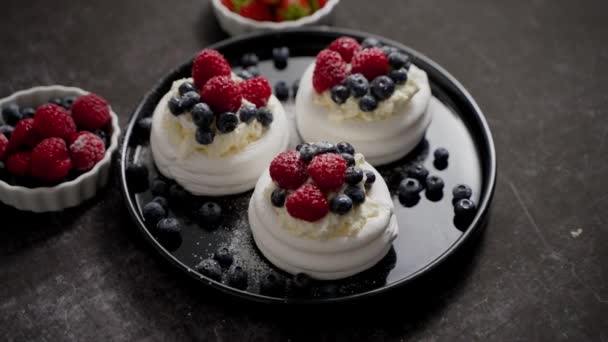 Delicious mini pavlova meringue desserts served with frozen frosty berries and mascarpone whipped cheese. Flat lay - Filmati, video