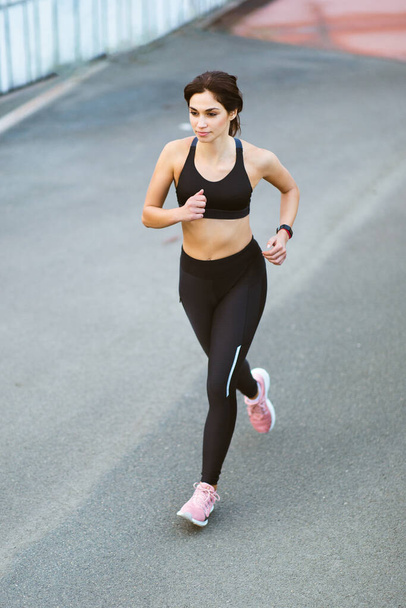 Full body portrait of slim and fit young woman running outdoors  - Φωτογραφία, εικόνα