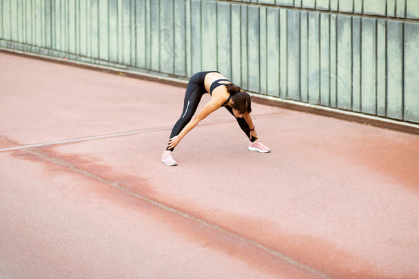Retrato de comprimento total de mulher jovem em sportswear exercendo ao ar livre de manhã - Foto, Imagem