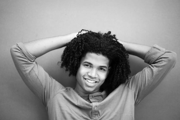 Fekete-fehér portré fiatal afro-amerikai férfi pózol a kezét a fej mögött - Fotó, kép
