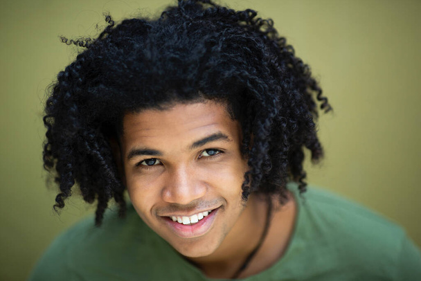 Nahaufnahme des Gesichts eines glücklichen afrikanisch-amerikanischen Mannes mit lockigem Haar - Foto, Bild
