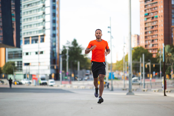 Активный спортсмен бегает на улице города - Фото, изображение
