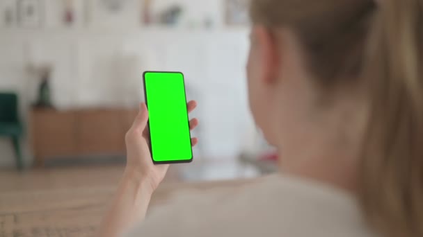 Вид сзади на молодую женщину с помощью смартфона с зеленым хроматическим экраном  - Кадры, видео