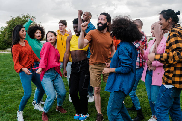 Ομάδα νέων πολυεθνοτικής καταγωγής που χορεύουν μαζί σε εξωτερικούς χώρους - Φωτογραφία, εικόνα