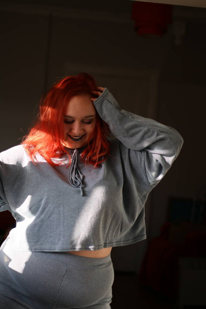 Plus size female with red hair wearing a grey lounge suit - Φωτογραφία, εικόνα