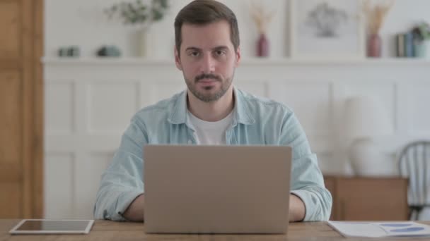 Casual Man Smiling at Camera while using Laptop - Imágenes, Vídeo