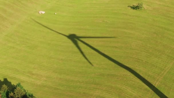 A shadow of a windmill on the yellow field. Renewable energy production concept. - Πλάνα, βίντεο