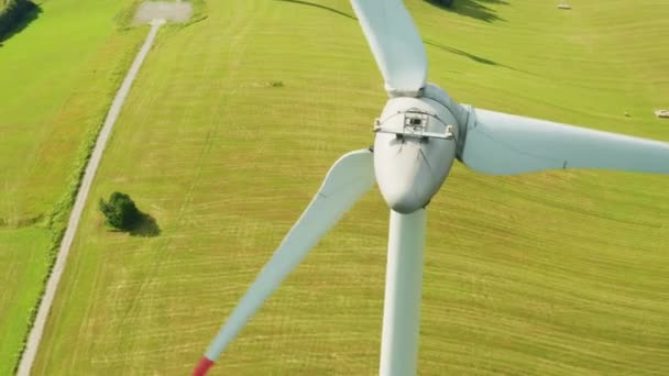 Zoom out of camera from a propeller of the windmill in the field with mountains on the background. - Video