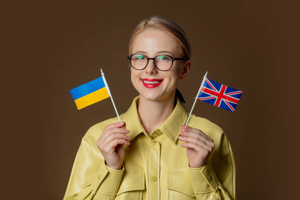 Stylish white girl with two flags, Ukrainian and Great Britain - Foto, Bild