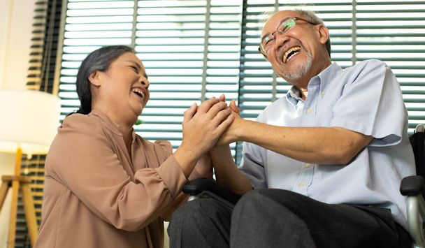 Senior Elderly Couple hold hands together after retirement, Husband wife person take care each other in romantic time with smile happy enjoy. Asian grandparent sit on wheel chair looking, copy space - Foto, Bild