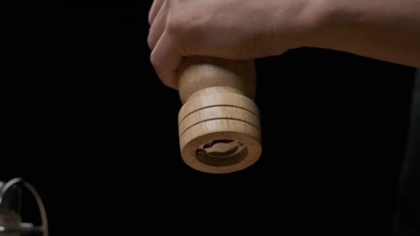 Close-up of a chefs hands grinding pepper with a hand pepper mill. Slow motion - Materiał filmowy, wideo