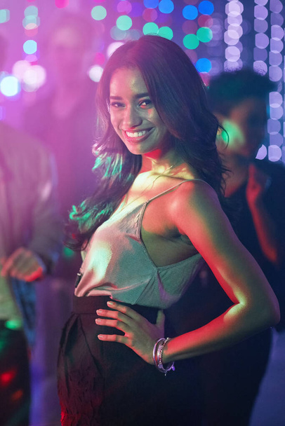 Сияющий уверенностью. Портрет красивой молодой женщины, позирующей на танцполе в ночном клубе - Фото, изображение