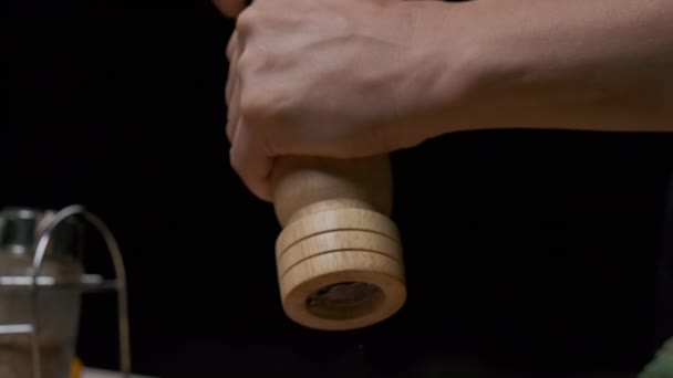 Close-up of a chefs hands grinding pepper with a hand pepper mill. Slow motion - Materiał filmowy, wideo