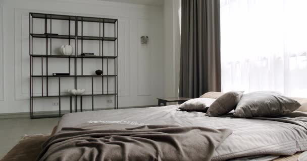 Elegance white and brown interior design. Minimalist white Bedroom. Modern Hotel Bedroom Interior and bed with many pillows. Minimalistic style of interior. Interior with shelves on white wall. - Filmmaterial, Video