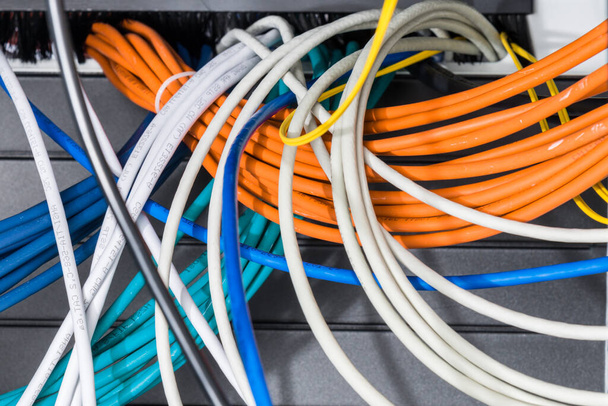 kilka kabli sieciowych posortowanych w szafie rack, prowadzących z panelu patch w szafce serwerowej w pokoju centrum danych - Zdjęcie, obraz