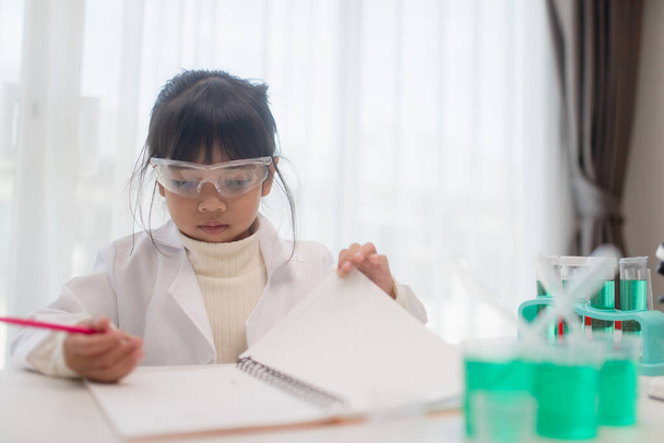 onderwijs, wetenschap, chemie, en kinderen concept - kinderen of studenten met reageerbuis maken experiment op school laboratorium - Foto, afbeelding