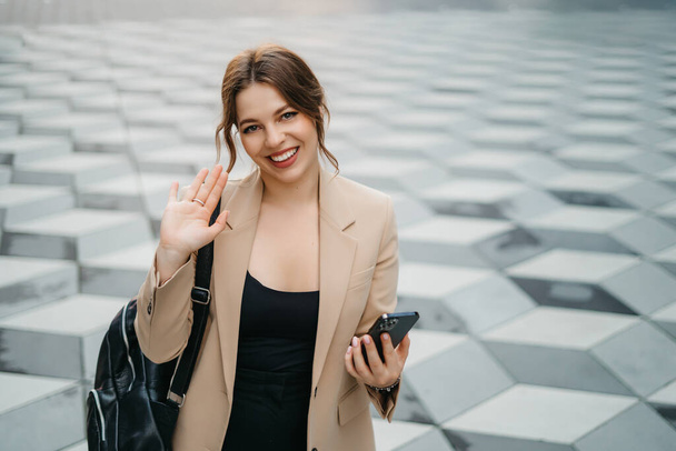 Szczęśliwa kobieta za pomocą aplikacji mobilnej na smartfonie, aby zadzwonić wideo, machając i witając przyjaciół lub rodzinę, rozmawiając na rozmowy wideo, pozostając w kontakcie na odległość. Wysokiej jakości zdjęcie - Zdjęcie, obraz