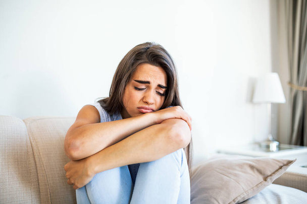 Young woman sit on couch feels unhappy desperate thinking about personal difficulties mental health problems, depressed and anxious woman need psychological support. - Foto, Imagem