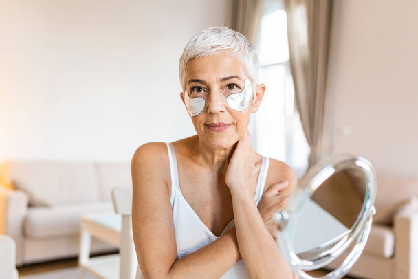 Beauty portrait of middle age woman with wrinkles and a silver patch under eyes. Collagen mask and spa concept. Copy space. Summer skin care - Fotoğraf, Görsel