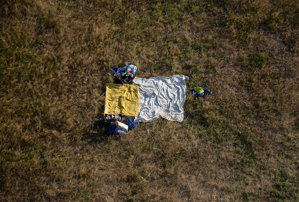 rest cabin, tourist shelter on the meadow. view from a drone. blankets for camping. camping and sensual games. lovers had a romantic moment in the meadow. rolled blanket after making love - Φωτογραφία, εικόνα