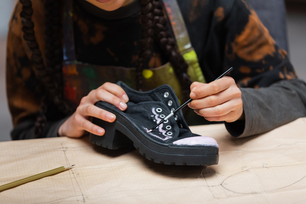 Cropped view of african american craftswoman painting on shoe on sewing pattern in workshop  - Fotografie, Obrázek